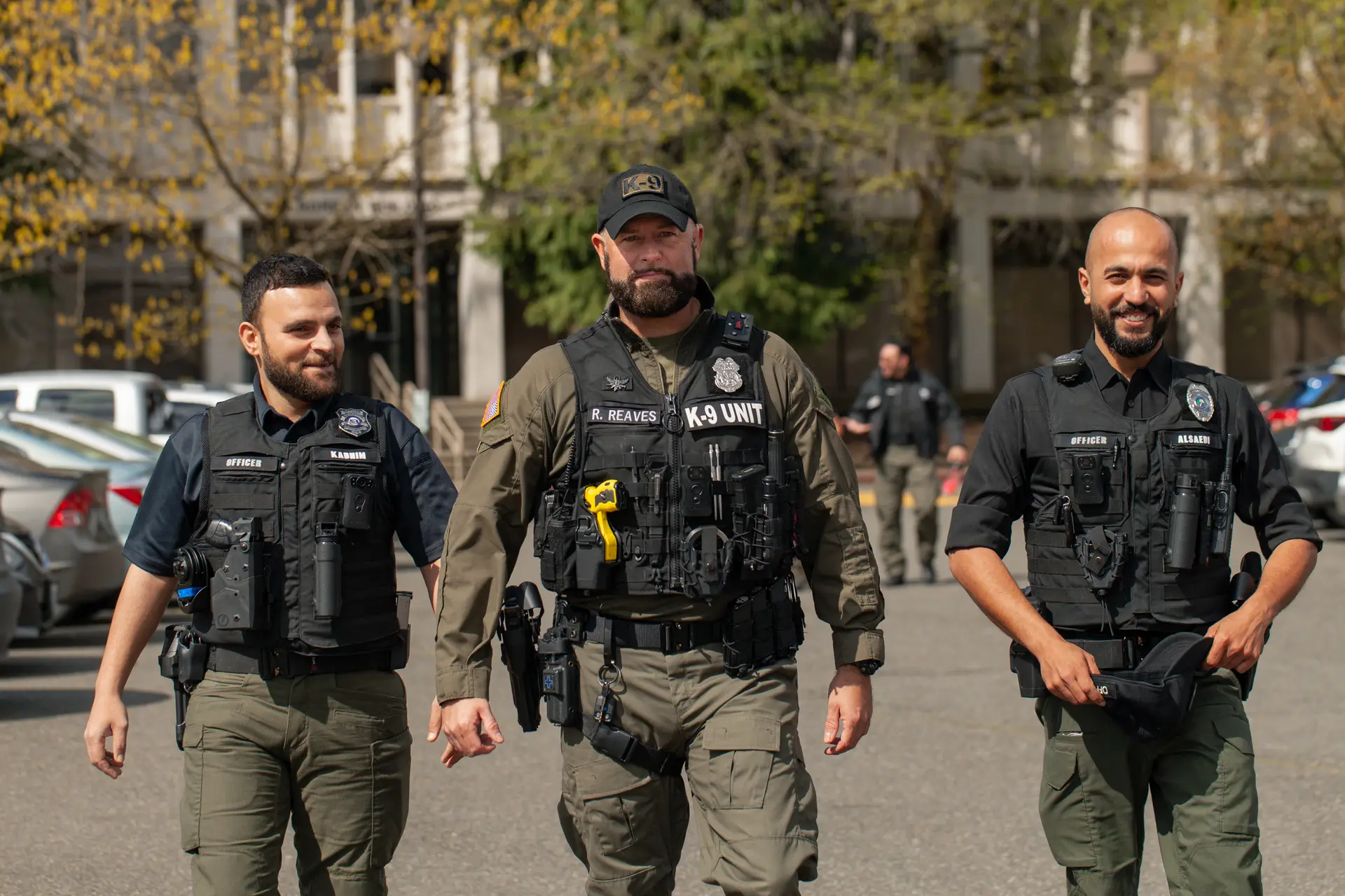 Three Evergreen Off Duty security officers in tactical vests walking together outdoors